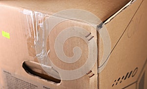 Metal staples on the corner of a cardboard box.Box staplers ensure fast and secure lid closing.A closeup of a brown cardboard box.