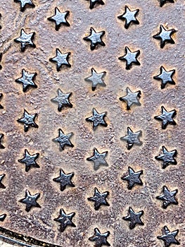 Metal stars of steel texture on a sewer manhole