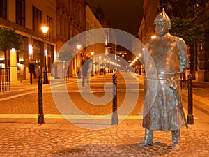 Metal statue policeman watching the street by night.