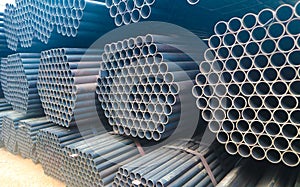 Metal steel and aluminium pipe heap in the cargo warehouse for transportation and logistics to the manufacturing factory