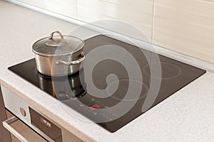 Metal steel saucepan in modern kitchen with induction stove.