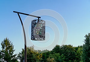 Metal street lamp with an openwork plafond against the background of the evening sky