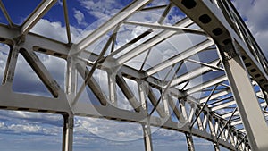 Metal structure of the bridge against the moving clouds