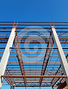 metal structure of a building on concrete columns against a blue sky background