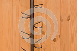 Metal structure clothes hanger hooks on wooden background close-up