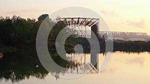 Metal structure on the river at sunset