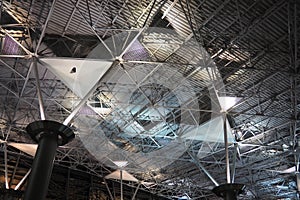 Metal structures under the ceiling. Decorative details of the airport ceiling . Concrete beams, glass windows and metal