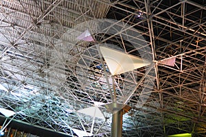 Metal structures under the ceiling. Decorative details of the airport ceiling . Concrete beams, glass windows and metal