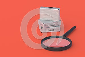 Metal suitcases near magnifying glass on red background. Search for office work