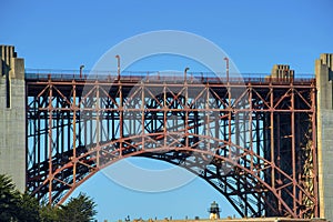 Metal sunsepnsion bridge arched center with steel and metal girders and beams with red color near golden gate crossing