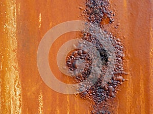 Metal surface with an orange coating that rusts with age photo