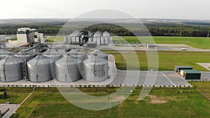 Metal tanks of the elevator. Grain drying complex in the open air. Commercial granaries. Steel warehouse for