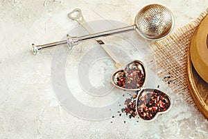 Metal tea infuser with leaves. Composition with tea accessories on a white background