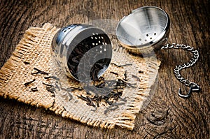 Metal tea infuser on wooden table photo