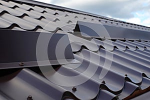 Metal tile roofing construction. Close up snow guard on the roof.