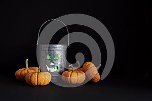 Metal tin with candle and gourds on black