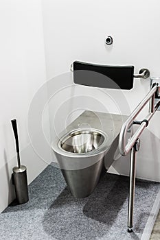 The metal toilet with grab bars for disabled and elderly people