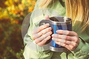 Metal touristic tea cup in Woman hands Outdoor