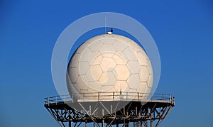 White spherical radar for satellites receiving on a metal structure  over blue sky