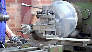 Metal trade. Milling machine operator working. Zoom out of turning lathe in action.