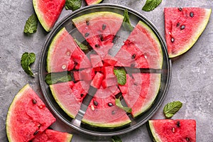 Metal tray with slices of ripe watermelon on grey table