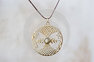 Metal tree shape pendant round mandala on neutral background