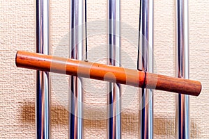 Metal tubular bells with a bamboo tube hang on the wall and create the music of the wind