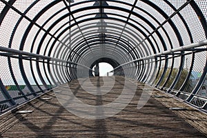 Metal tunnel bridge with wooden walkway