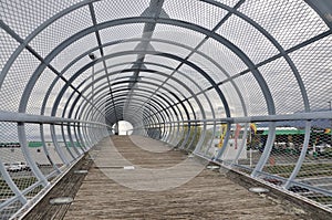 Metal tunnel bridge with wooden walkway.