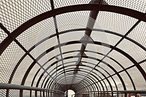 Metal tunnel bridge with wooden walkway.