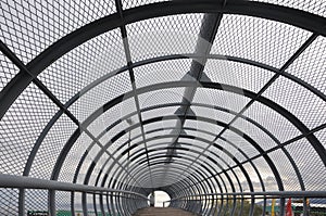 Metal tunnel bridge with wooden walkway.