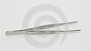 Metal tweezers rotate in a circle close-up
