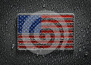 Metal US American flag covered in water drops.