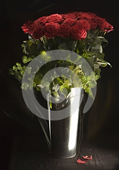Metal vase of a bunch of red roses
