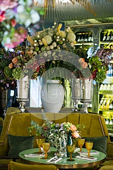 Metal vases in the form of a goblet with bouquets of flowers are on the tabl