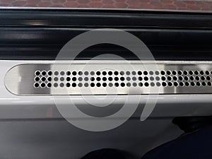 Metal vent with holes near window on public train transportation