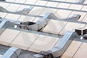 Metal ventilation ducts and tubes on a rooftop.