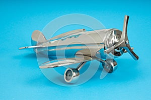 Metal vintage aircraft toy, with front propeller. Retro toy on blue background