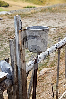 metal washstand with a conical valve attached to a picket fence