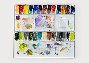 Metal watercolor palette box with colorful watercolor set on a white background