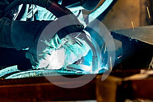 Metal welding worker at work in an electromechanical workshop