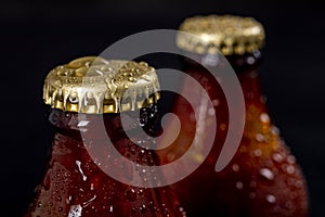 Metal wet cap on a dark glass bottle. A tasty drink closed with a cap.