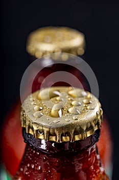 Metal wet cap on a dark glass bottle. A tasty drink closed with a cap.