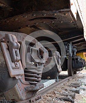 Metal wheels of a train. Lower undercarriage. The carriage stands on the rails. Abandoned rusty locomotive. The chassis