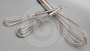 Metal whisks on gray background