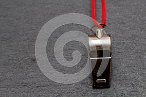 Metal whistle on dark slate background