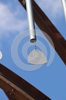 Metal wind chime sculpture against sky, chime close-up