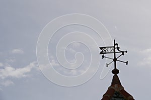 Metal wind pointer on the top of a tower.