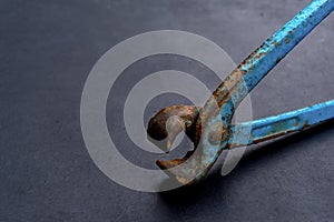 Metal wire cutter, old gripper on a dark gray background.