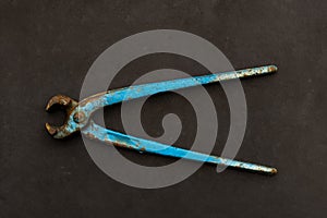 Metal wire cutter, old gripper on a dark gray background.